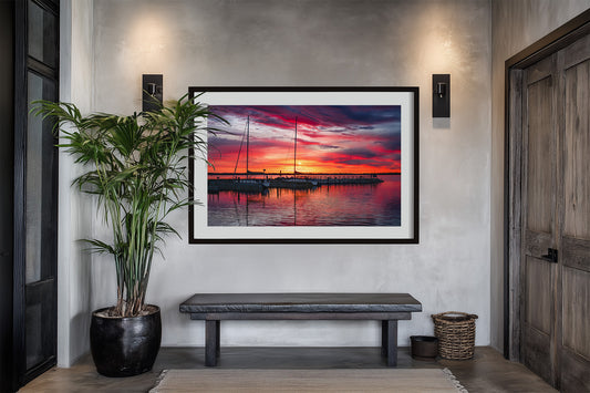 Northport Marina on Grand Traverse Bay with sailboats at sunrise under a vibrant red, orange and blue sky. Framed in entryway.