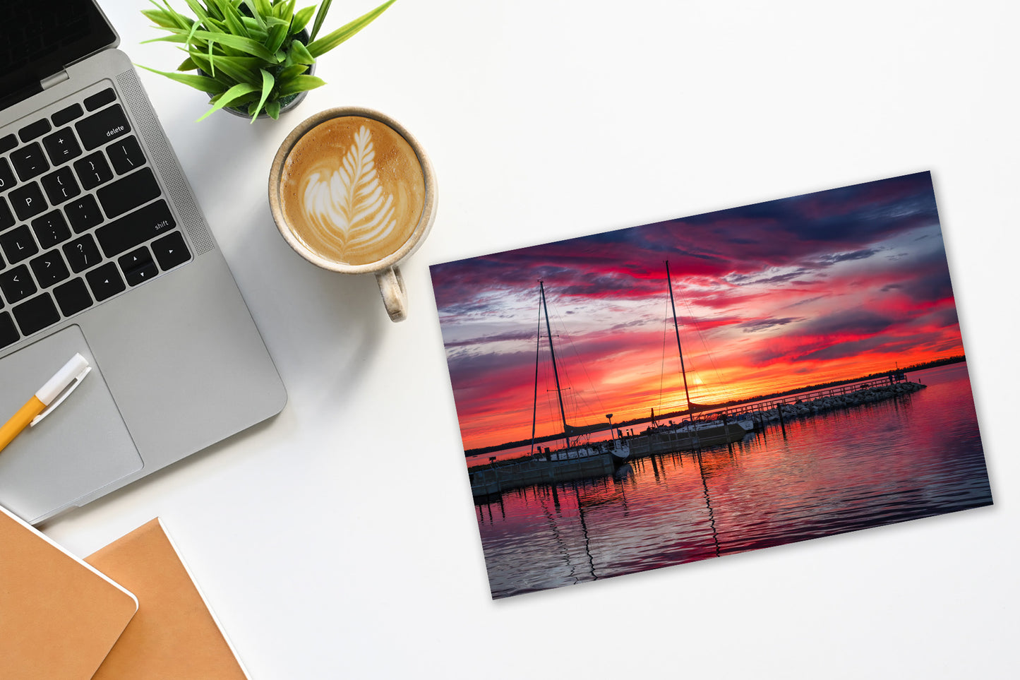 Northport Marina on Grand Traverse Bay with sailboats at sunrise under a vibrant red, orange and blue sky on a desktop with computer