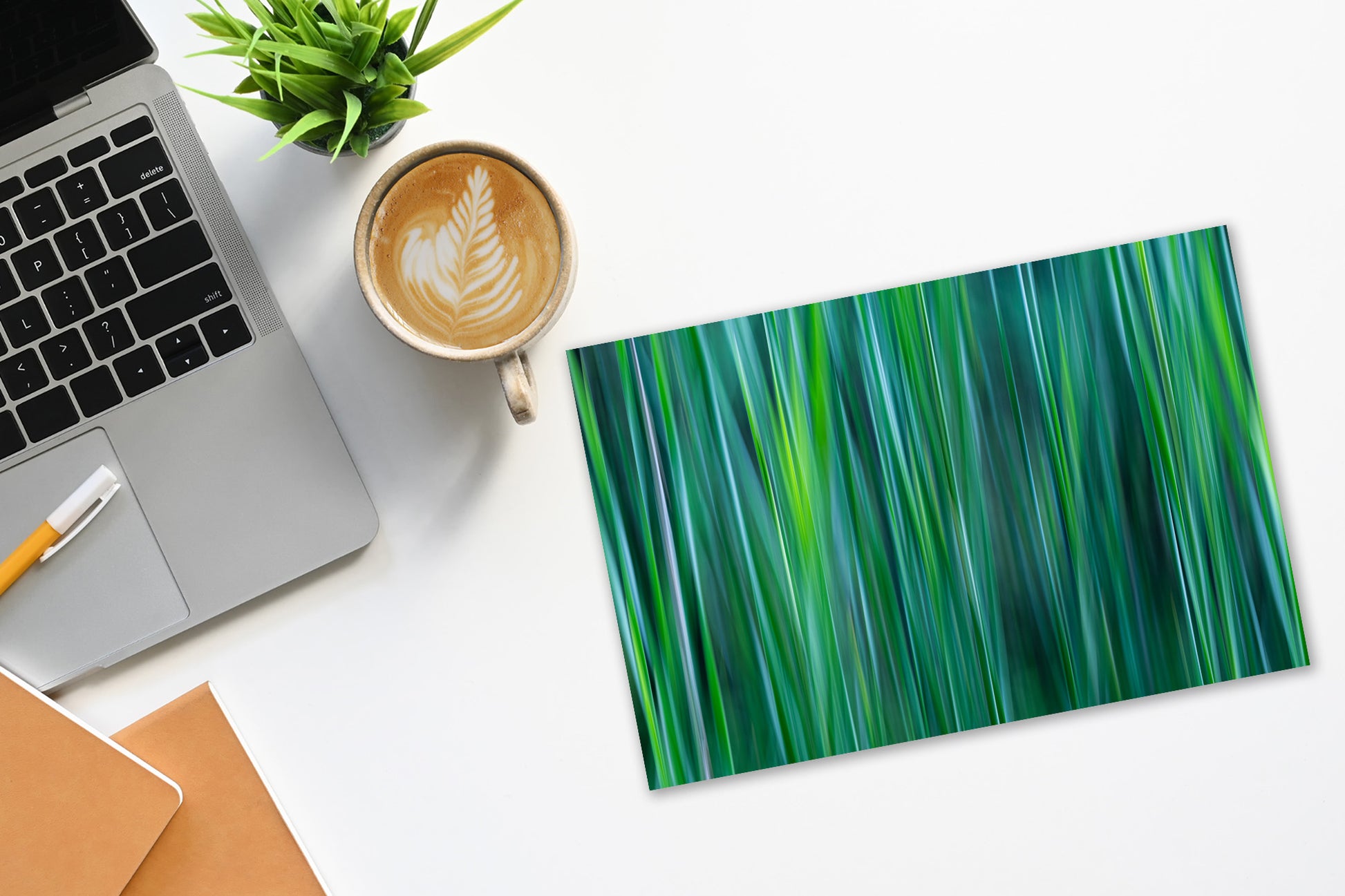 desktop with nature print  with cattail leaves in abstract using shades of green, jade, teal and gray.   