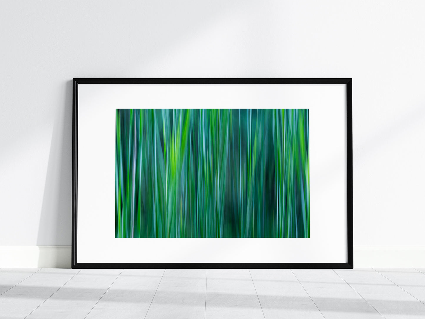 Black framed print with white mat of shades of green, aqua, teal and gray cattail leaves.  Intentional camera movement technique.