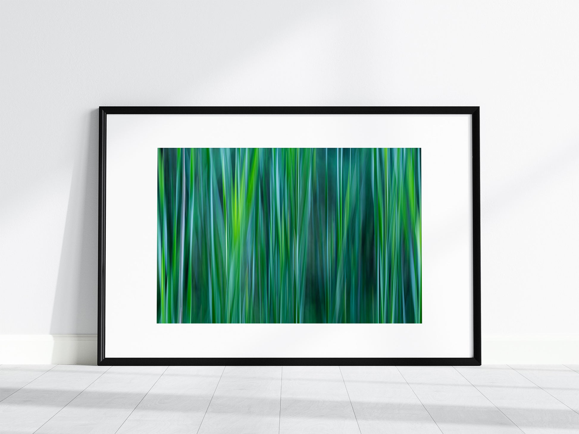 Black framed print with white mat of shades of green, aqua, teal and gray cattail leaves.  Intentional camera movement technique.