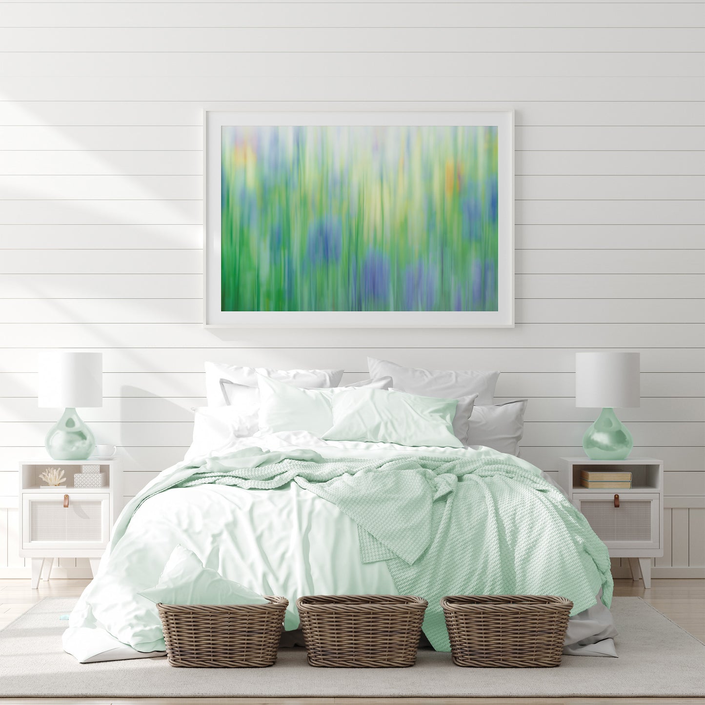 Framed lilac cornflowers captured with intentional camera movement over a coastal white bedroom 