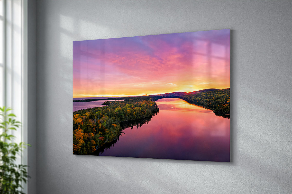 A rectangular wall art print of an Aerial view of Lake Fanny Houe with forested banks, mounted on a light gray wall in an interior setting.