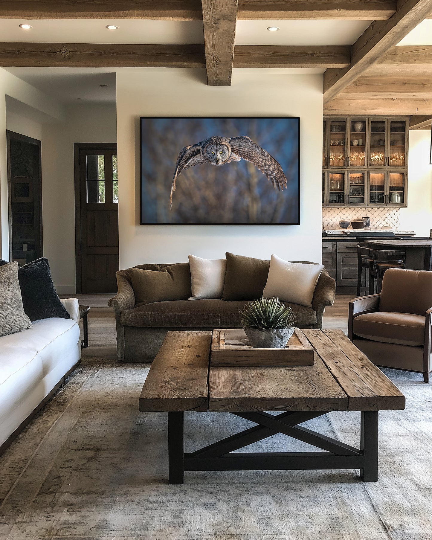 Framed great gray owl print in modern living room with brown sofa, white rug, and wooden coffee table.