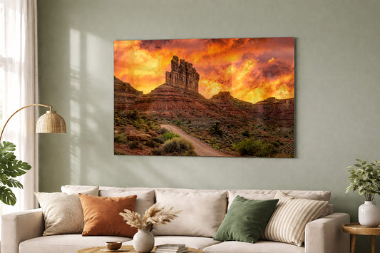 Metal print of Valley of the Gods iconic formations with an intense sunset shown on a wall above a beige sofa with decorative pillows.